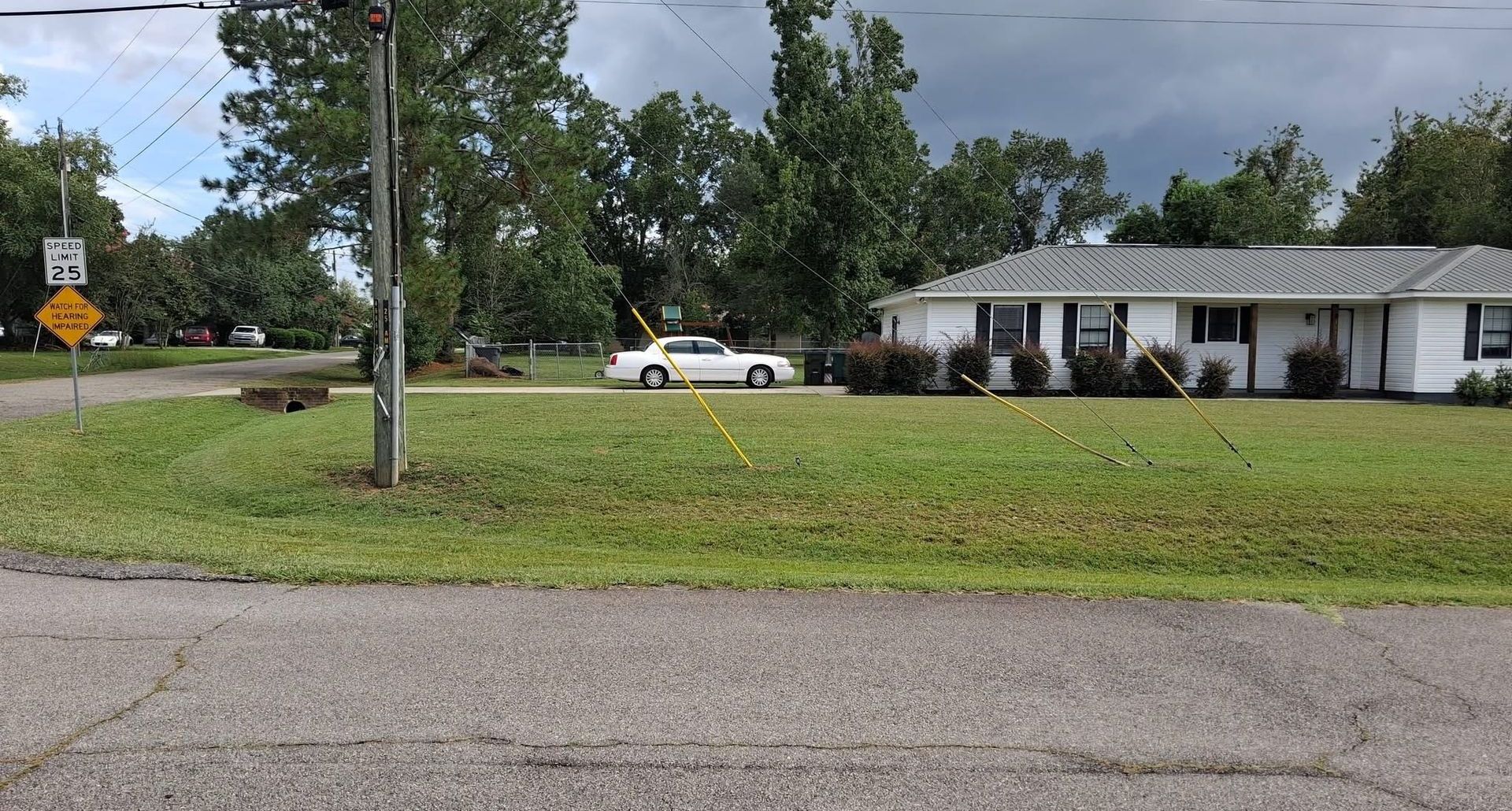 Freshly mowed corner lot in front of a white home